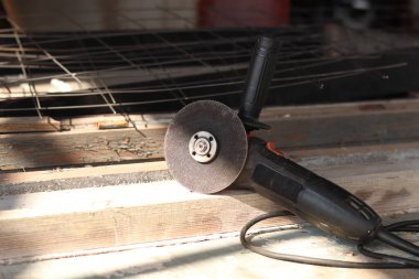 Açı öğütücüler, inşaat ve onarım için elektrikli aletler. Sert materyalleri kesip öğütmek için bir araç. Kablosu olan eski bir kıyma makinesi. Ülkedeki tamirat işleri. Metal diskle öğütücü