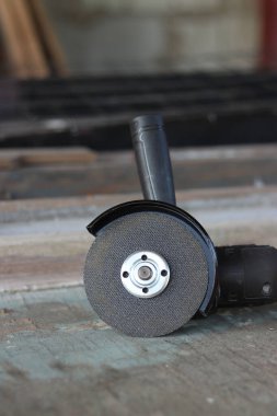 Metal kesici diskli kablosuz öğütücü, yakın plan. Kulübede ya da inşaatta tamirat. Kablosuz kablosuz öğütücü. Elektrikli aletler, inşaat malzemeleri