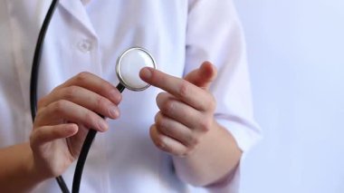 Close-up of a doctor's hands holding a stethoscope. Concept of medicine and health. Cardiologist in a white coat with a stethoscope in his hands. Doctor, nurse or intern. Medical instrument