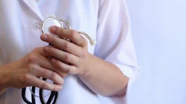 Close-up of a doctor's hands holding a stethoscope. Concept of medicine and health. Cardiologist in a white coat with a stethoscope in his hands. Doctor, nurse or intern. Medical instrument