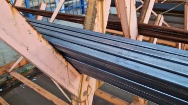 Rectangular steel profile pipes in a metal warehouse, selective focus. Building materials. Close-up of rectangular metal profile pipes stacked together. Building materials warehouse