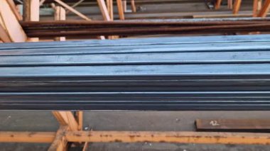 Rectangular steel profile pipes in a metal warehouse, selective focus. Building materials. Close-up of rectangular metal profile pipes stacked together. Building materials warehouse