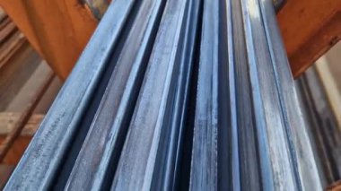 Rectangular steel profile pipes in a metal warehouse, selective focus. Building materials. Close-up of rectangular metal profile pipes stacked together. Building materials warehouse