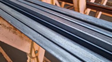 Rectangular steel profile pipes in a metal warehouse, selective focus. Building materials. Close-up of rectangular metal profile pipes stacked together. Building materials warehouse