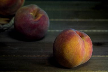 Ondan siyah arka plan-Güz hasat kompozisyon karşı ahşap masa üzerinde dökülen üç meyve ile kova şeftali çevirdi 