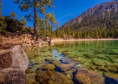 Lake Tahoe North, kum limanının uzun pozlama Nevada county, California, ABD, aqua şeffaf su, mavi bir bulutsuz gökyüzü üzerinde kayalık sahil featuring 