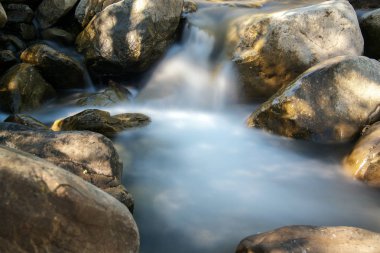 2017'nin özellikle fırtınalı kışından sonra, Kışlar, Kaliforniya, ABD'de Putah Creek'in bir kolundan akan suyun uzun pozlaması.