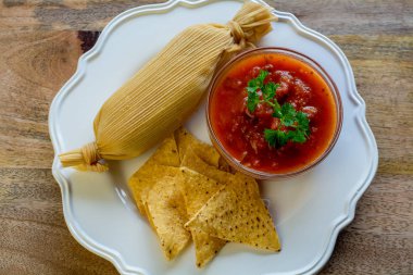 Tamale sıcak domates sosu ve ahşap tabl ekmeği ile servis