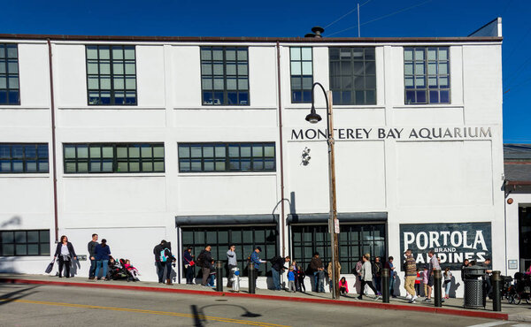 Monterey, CA - February 18, 2018. People line up in front of Monterey Bay Aquarium waiting for it to open on a sunday morning. Lines to enter the aquarium are common on the weekeneds. 