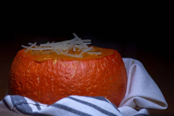 Pumpkin soup in baked mini-pumpkin wrapped in white dish cloth a — Stock Photo, Image