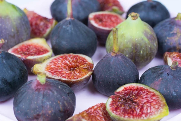 Taze incir. Vejetaryen yiyecekler. Beyaz bir arka plan üzerinde tüm ve dilimlenmiş incir. Yakın çekim.