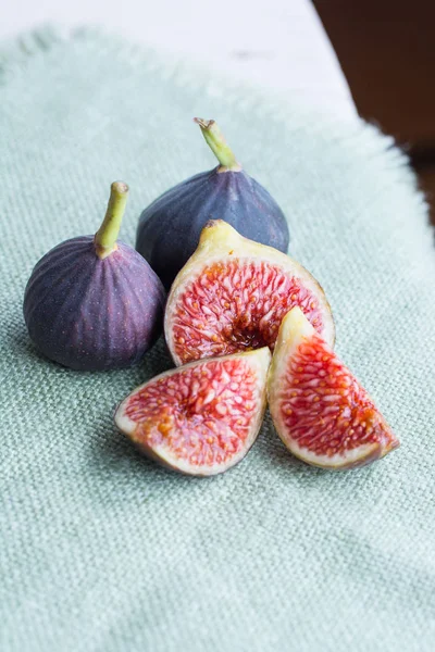 Taze incir. Vejetaryen yiyecekler. Bütün ve dilimlenmiş incir pastel keten kumaş arka plan üzerinde. Uzay kopyalayın. Yakın çekim.