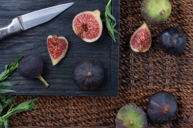 Taze incir. Vejetaryen yiyecekler. Bütün ve dilimlenmiş incir koyu ahşap arka plan üzerinde. Üstten görünüm. Yakın çekim.