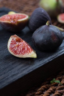 Taze incir. Vejetaryen yiyecekler. Bütün ve dilimlenmiş incir koyu ahşap arka plan üzerinde. Uzay kopyalayın. Yakın çekim.