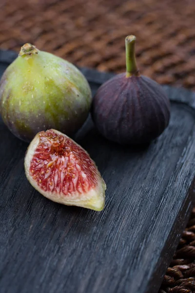 Taze incir. Vejetaryen yiyecekler. Bütün ve dilimlenmiş incir koyu ahşap arka plan üzerinde. Uzay kopyalayın. Yakın çekim.