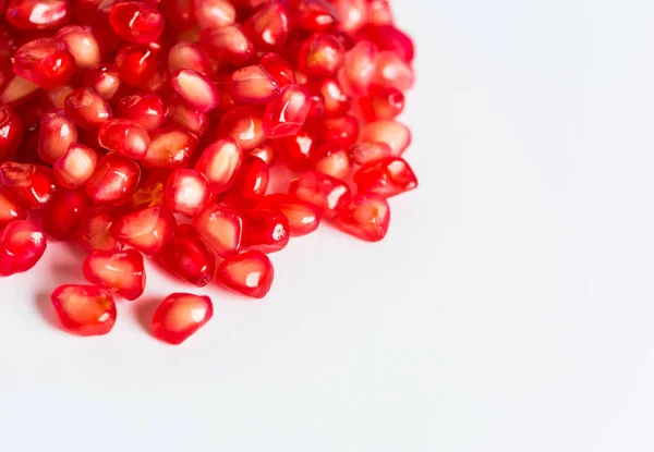 Nar taneleri. Soldaki beyaz arka plan üzerinde kırmızı nar tohumları. Boşaltmak.