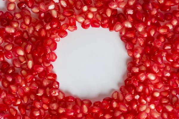 Beyaz zemin üzerine nar taneleri yuvarlak çerçeve. Mockup.