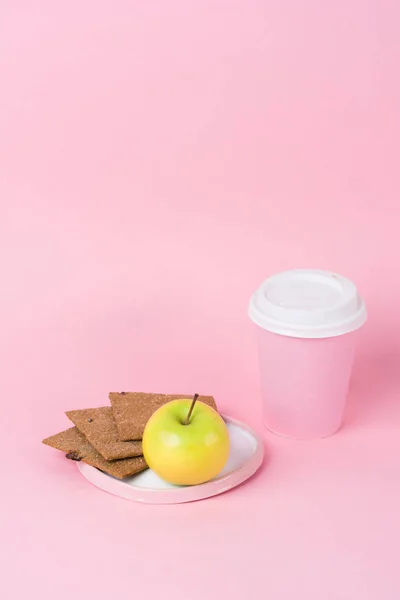 Kavram sağlıklı moda öğle yemeği. Diyet gevrek ekmek, elma ve kağıt üzerinde pastel pembe arka plan içkiyle Kupası. Yaratıcı konsept tarzı pop sanat odaya. Minimalizm.