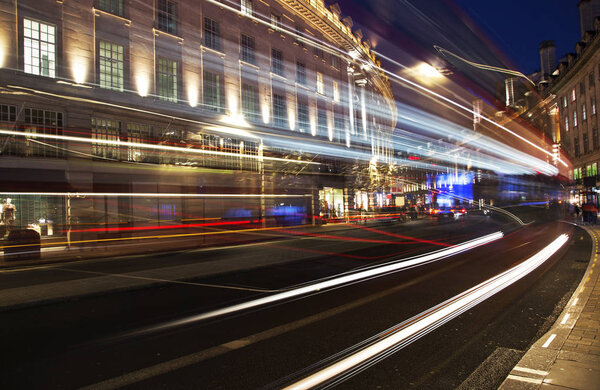 night scene of London city United Kingdom with the moving red buses and cars - long exposure photography