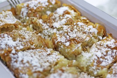 geleneksel Yunan bougatsa - krema ile doldurulmuş ve toz şeker ve tarçın ile süslenmiş phyllo hamur işi, yakın çekim
