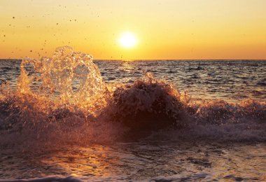 Paxos İyonya adaları Yunanistan'da bir plaj günbatımı sahne - kayalar isabet dalgalar sıçrama