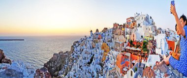 Santorini Yunanistan, Haziran 29 2019: Santotini Kiklad Yunanistan panoramik günbatımı sahne - turistler kaldera üzerinde geleneksel beyaz evlerin arasında yürüyüş. Editoryal kullanım.