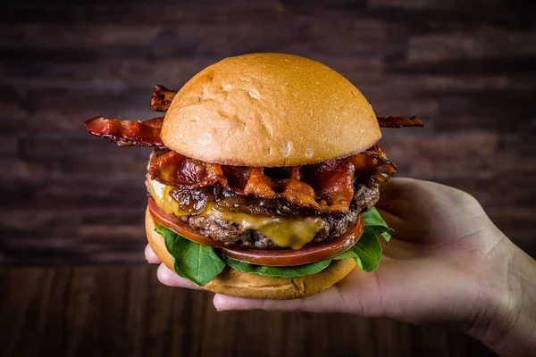 Ręczne trzymanie Hamburger z wołowiny rzemieślniczej — Zdjęcie stockowe
