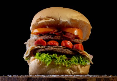 İki sığır etli burger, marul, domates, sosis, jambon, pastırma ve peynirli büyük ev yapımı burger, nam-ı diğer Brezilya 'da X-tudo.