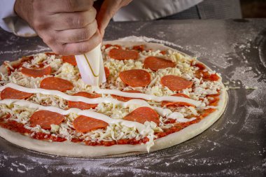 Domates sosu, mozzarella ve biberli taze pizza hamuru. Pizza yapma süreci.