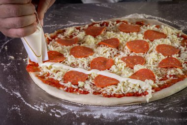 Domates sosu, mozzarella ve biberli taze pizza hamuru. Pizza yapma süreci.