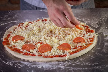 Domates sosu, mozzarella ve biberli taze pizza hamuru. Pizza yapma süreci.