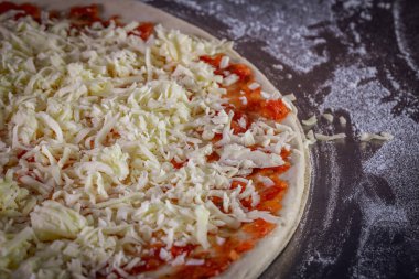 Domates sosu ve mozzarella ile hazırlanmış taze pizza hamuru. Pizz yapma süreci