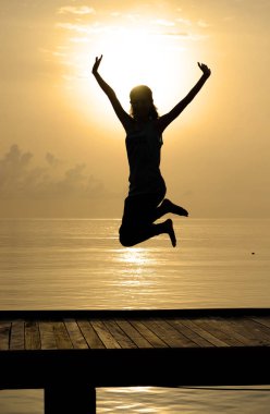 neşeli kız siluet üzerinde kaldırdı el ile havada atlama 