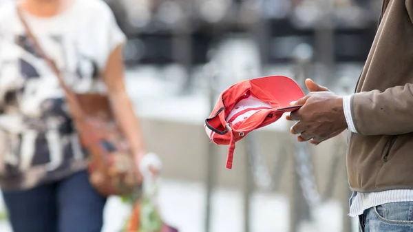 Orang Afrika Memegang Topi Merah Dan Mengemis Untuk Uang Orang — Stok Foto