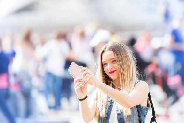 Pretty tourist teenager taking a photo with her mobile phone