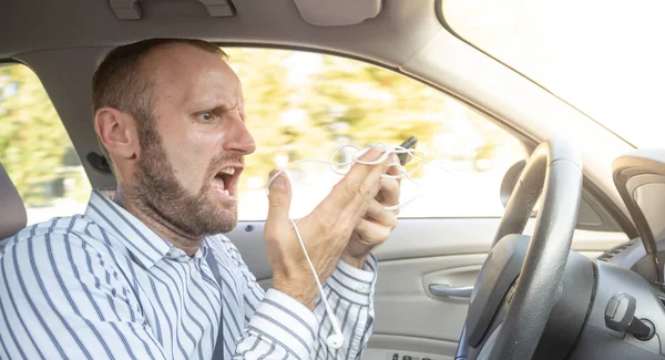 aggressive displeased man driving car and using mobile phone