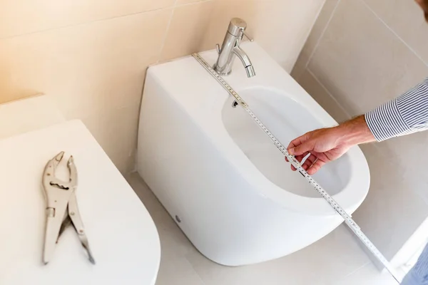 Arquitecto tomando medidas de un nuevo mobiliario de baño. Hom. — Foto de Stock