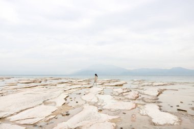 Issız bir kaya plajında yalnız kız