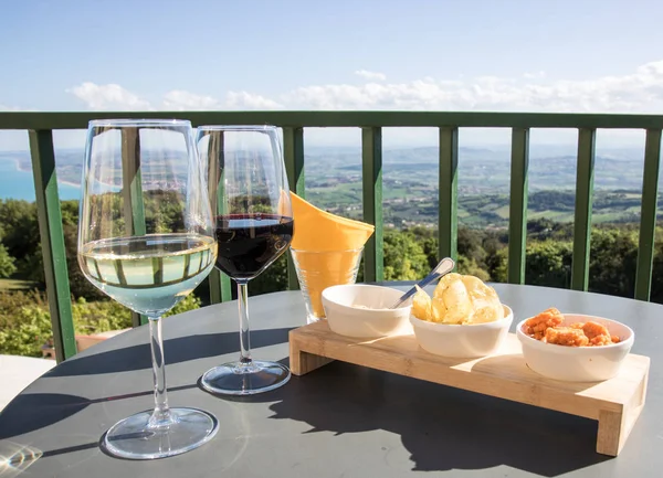 Aperitivo com vinho tinto e branco e um lanche — Fotografia de Stock