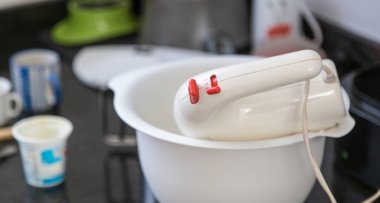 Kız evde yemek pişiriyor ve kek pişiriyor.