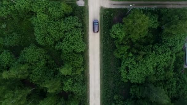 Сільська дорога. Автомобіль їде по дорозі між деревами і будинками . — стокове відео