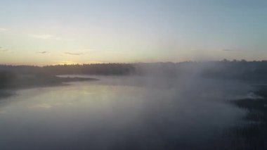 Sabah sis, şafak güneş ışınlarının gölde orman