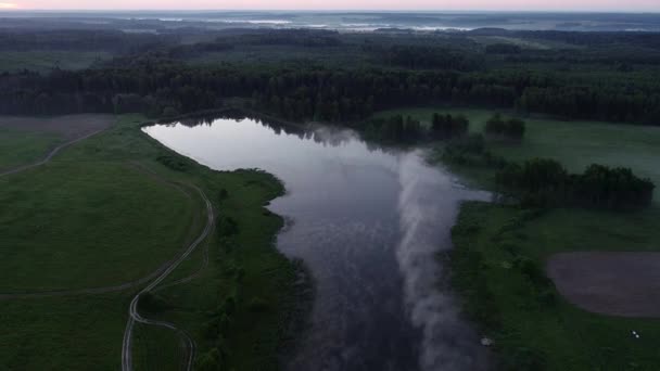 Лесное озеро в утреннем тумане, в лучах утреннего солнца — стоковое видео