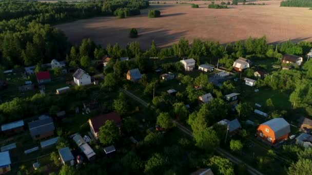 Vacker liten by nära jordbruksområdet i en vacker grön skog. — Stockvideo