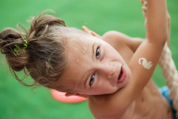 Petit garçon grimpant une corde sur la plage — Photo