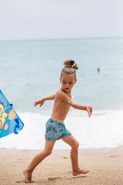 Petit garçon courir sur la plage avec un cerf-volant — Photo