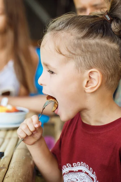 Boy eating pancake with banana and chocolate — Stock Photo, Image