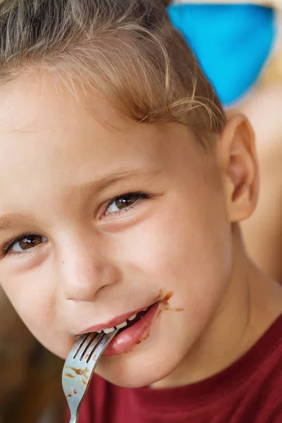 Ragazzo mangiare pancake con banana e cioccolato — Foto Stock