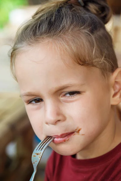 Ragazzo mangiare pancake con banana e cioccolato — Foto Stock