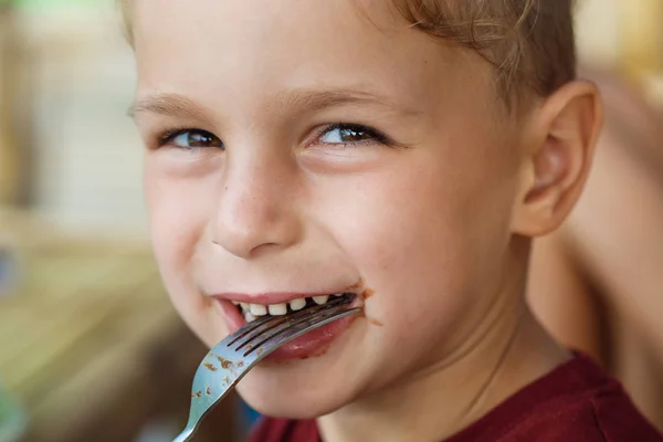 Junge isst Pfannkuchen mit Banane und Schokolade — Stockfoto
